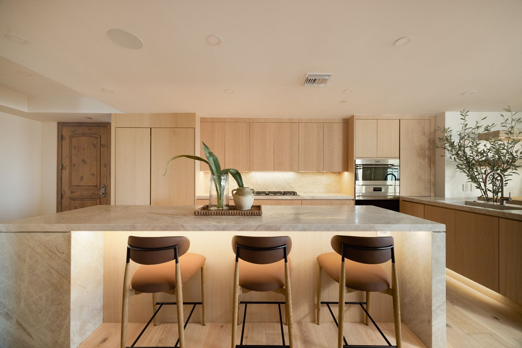 Under-lit waterfall island with bar seating