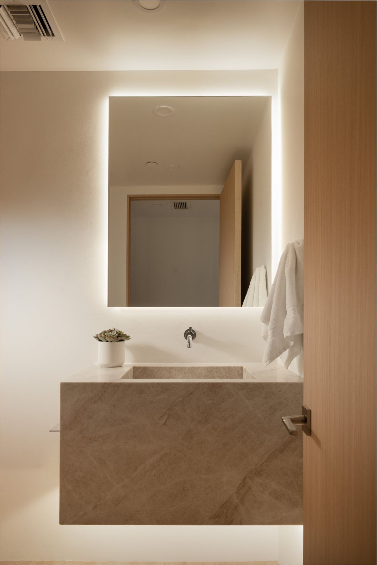 Powder room with backlit mirror