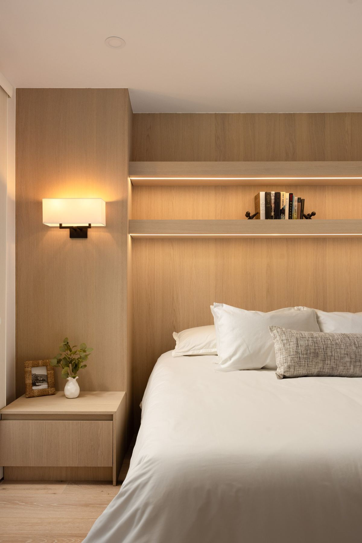 Guest bedroom with lit headboard shelving