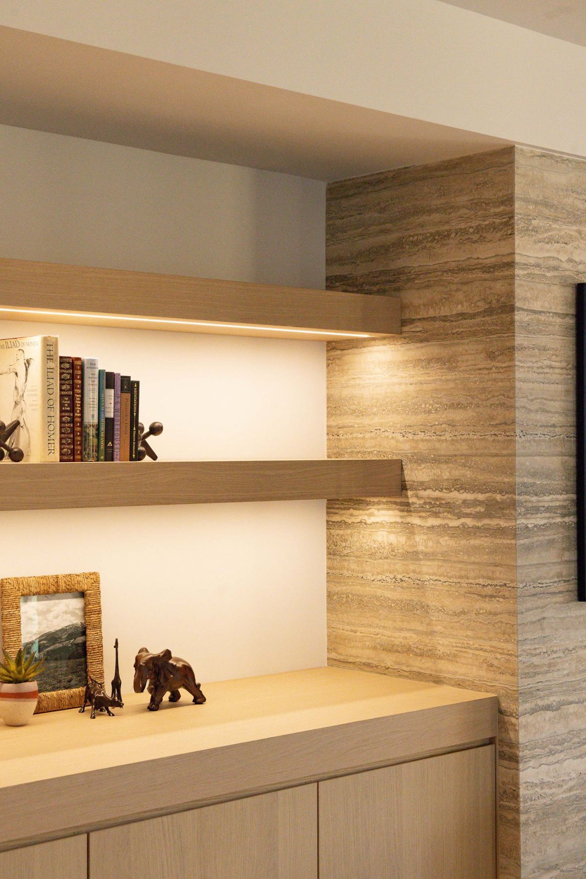 Stacked-stone wall & lit shelving